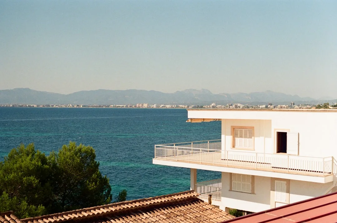 Weißes Ferienhaus mit Balkon und Blick auf das türkisfarbene Meer