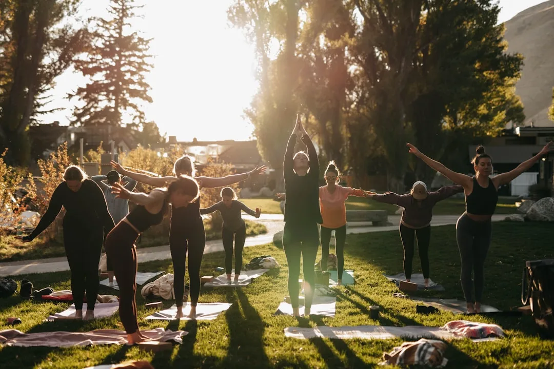 Gruppe Frauen beim Outdoor-Yoga im goldenen Abendlicht