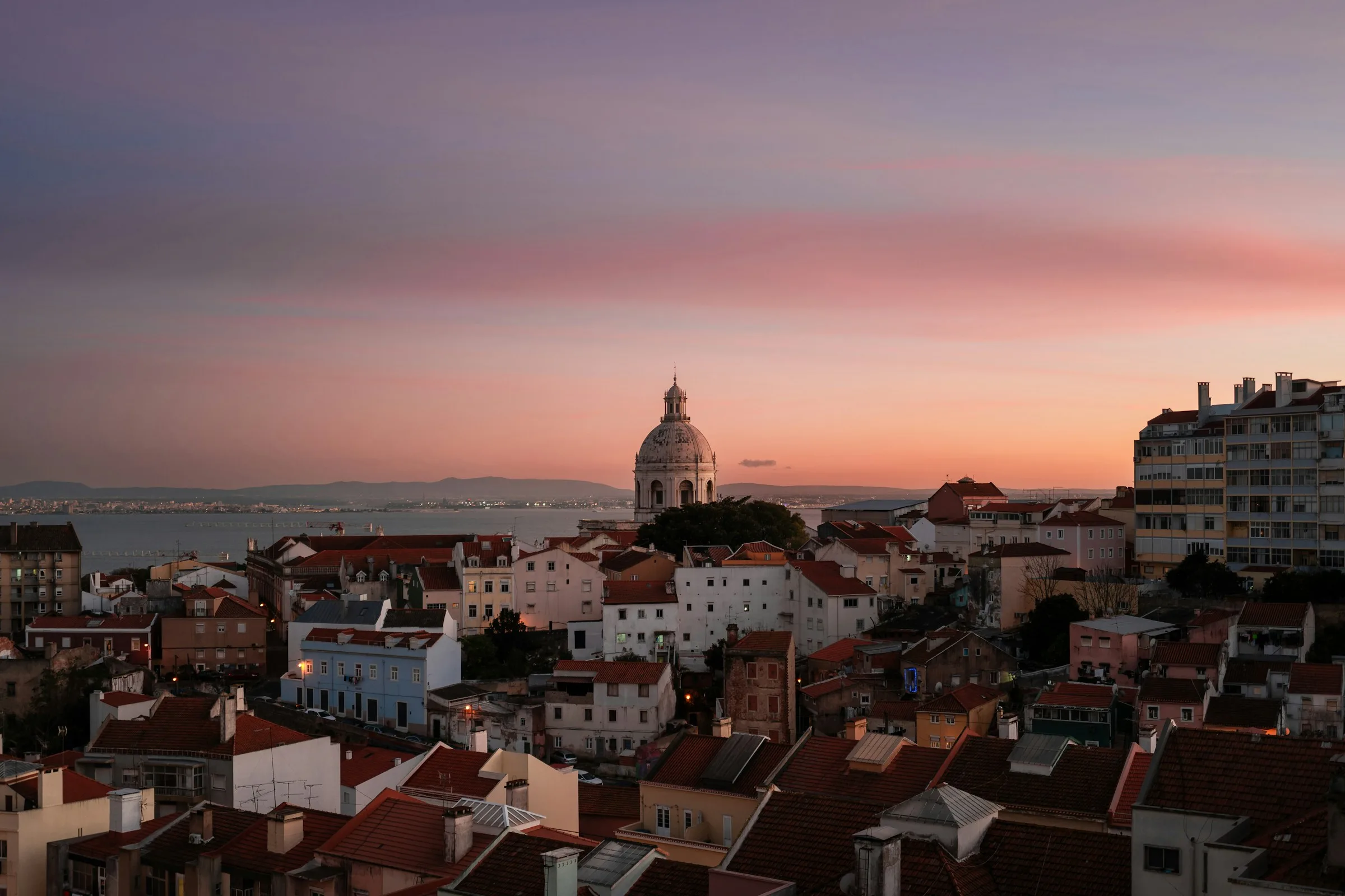 Lissabons Skyline leuchtet im Abendrot mit Kirchen und historischen Dächern