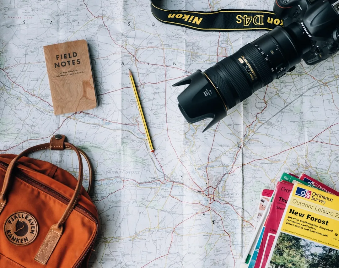 Travel flat lay with camera, travel book, map and backpack