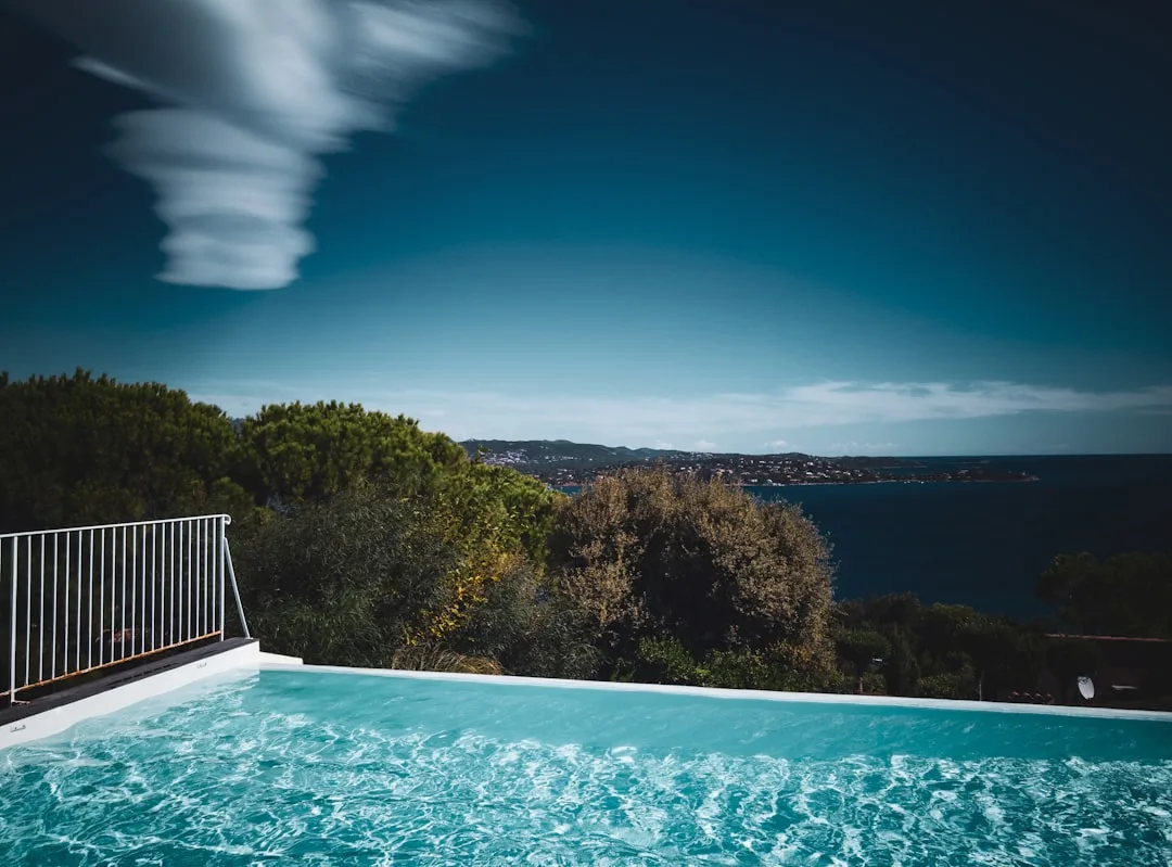 Infinitypool mit Panoramablick auf Meereslandschaft unter blauem Himmel
