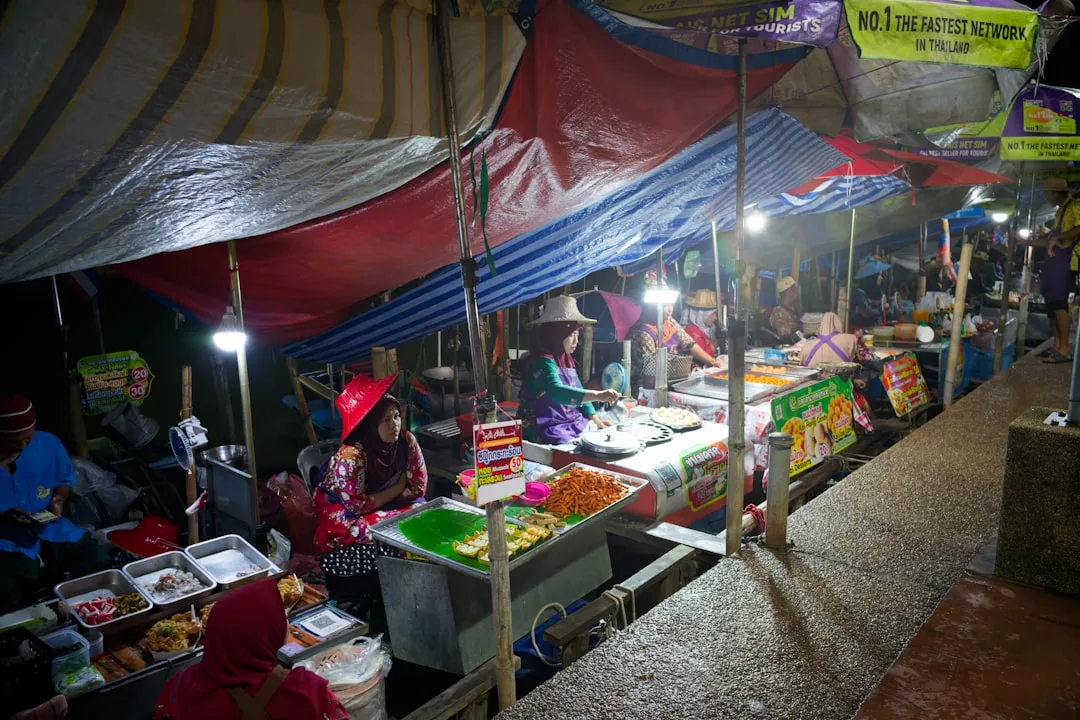Belebter Nachtmarkt mit bunten Marktständen und Händlern in Südostasien