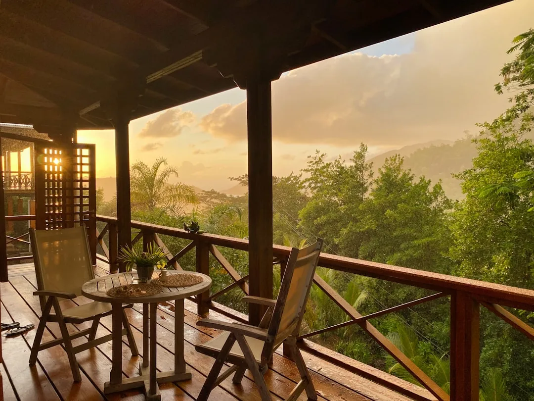 Wooden deck of an eco-lodge overlooking tropical rainforest canopy at dusk