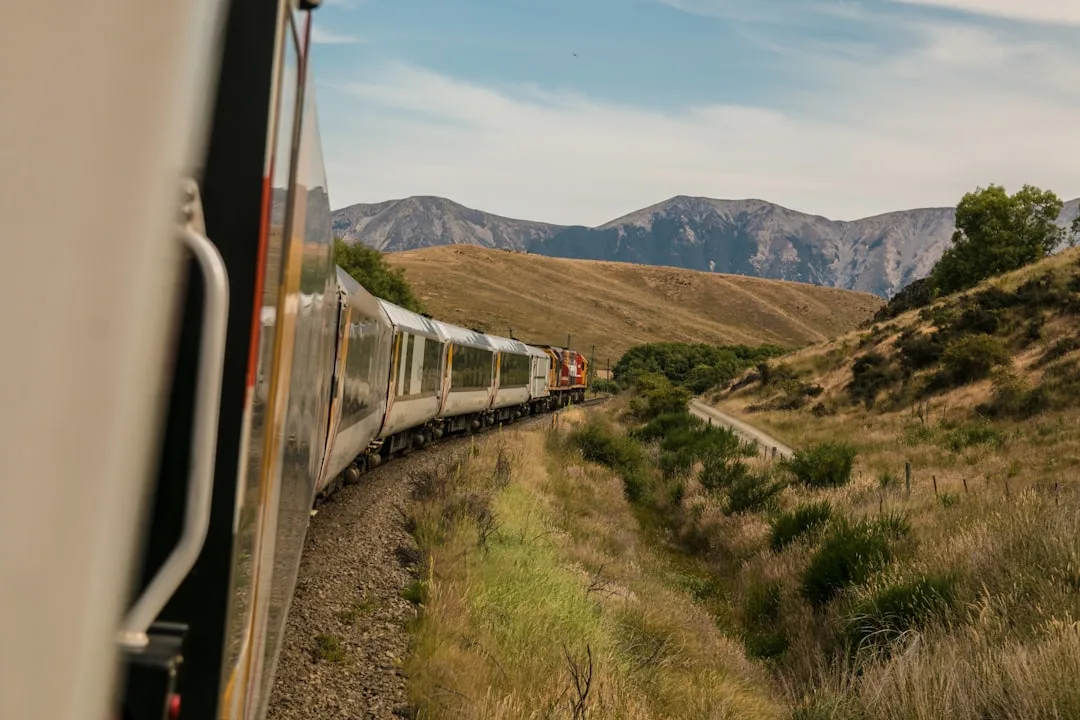 White train winding through a hilly mountain landscape